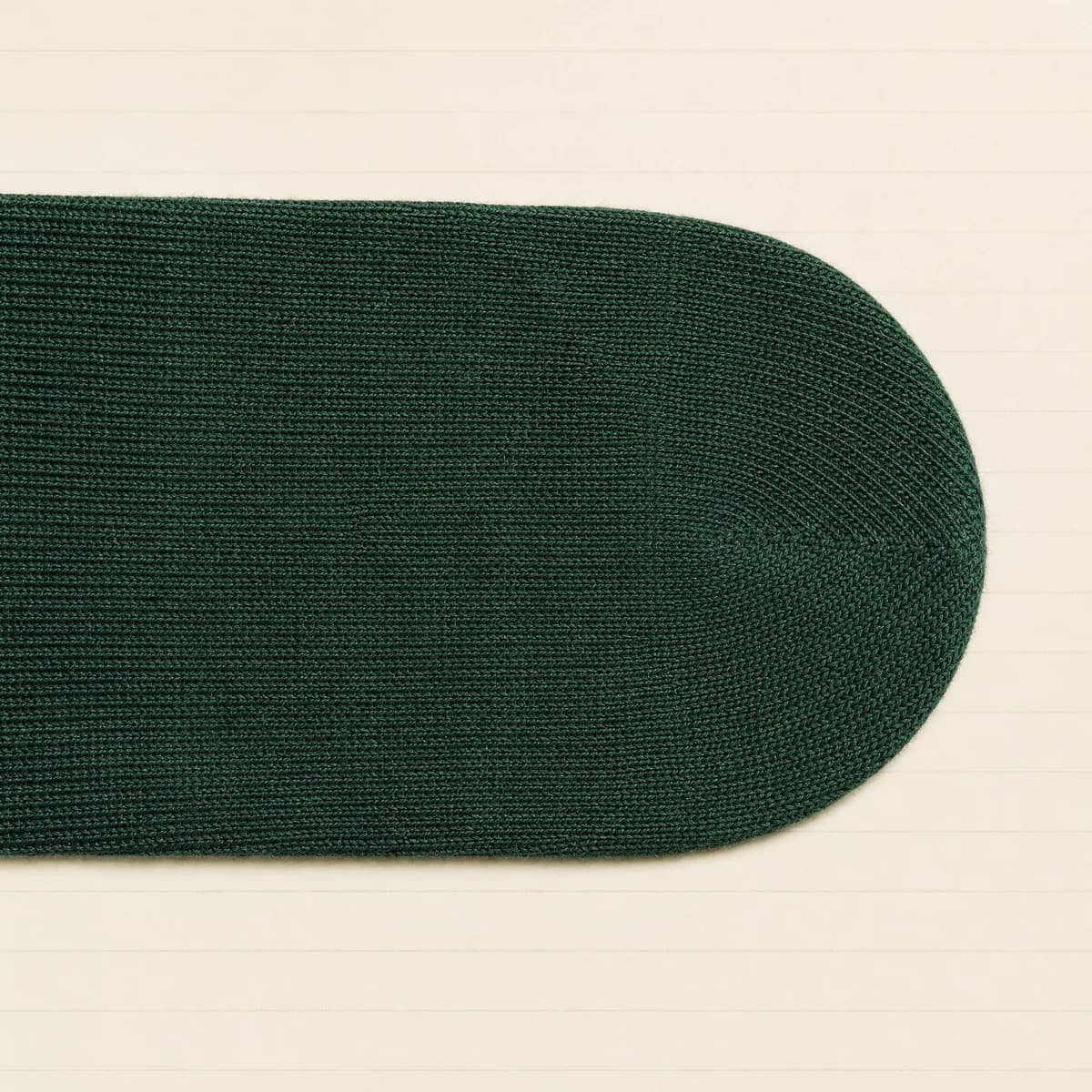 Extreme close-up of a flat linked toe seam where the knit continues across the join with no ridge.